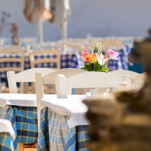 Greek beach with traditional blue table and chairs